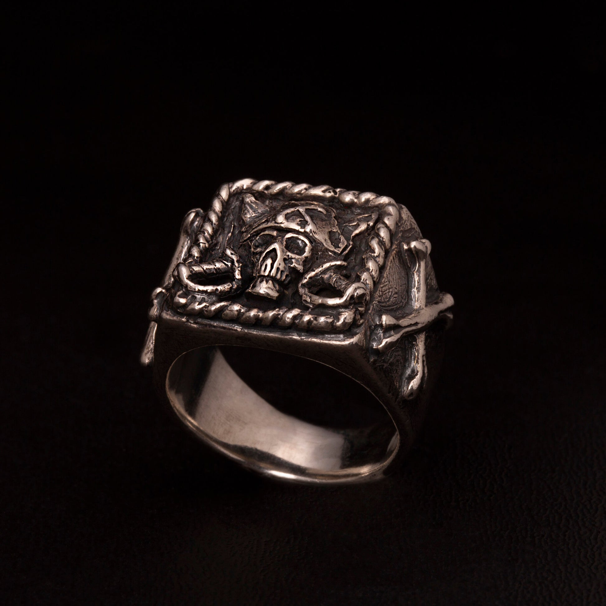 Anello chevalier in argento925 con teschio pirata ed ossa incrociate nei gambi laterali.