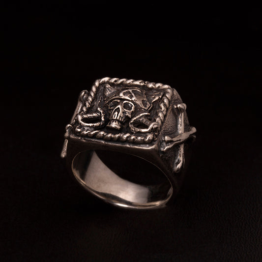 Anello chevalier in argento925 con teschio pirata ed ossa incrociate nei gambi laterali.