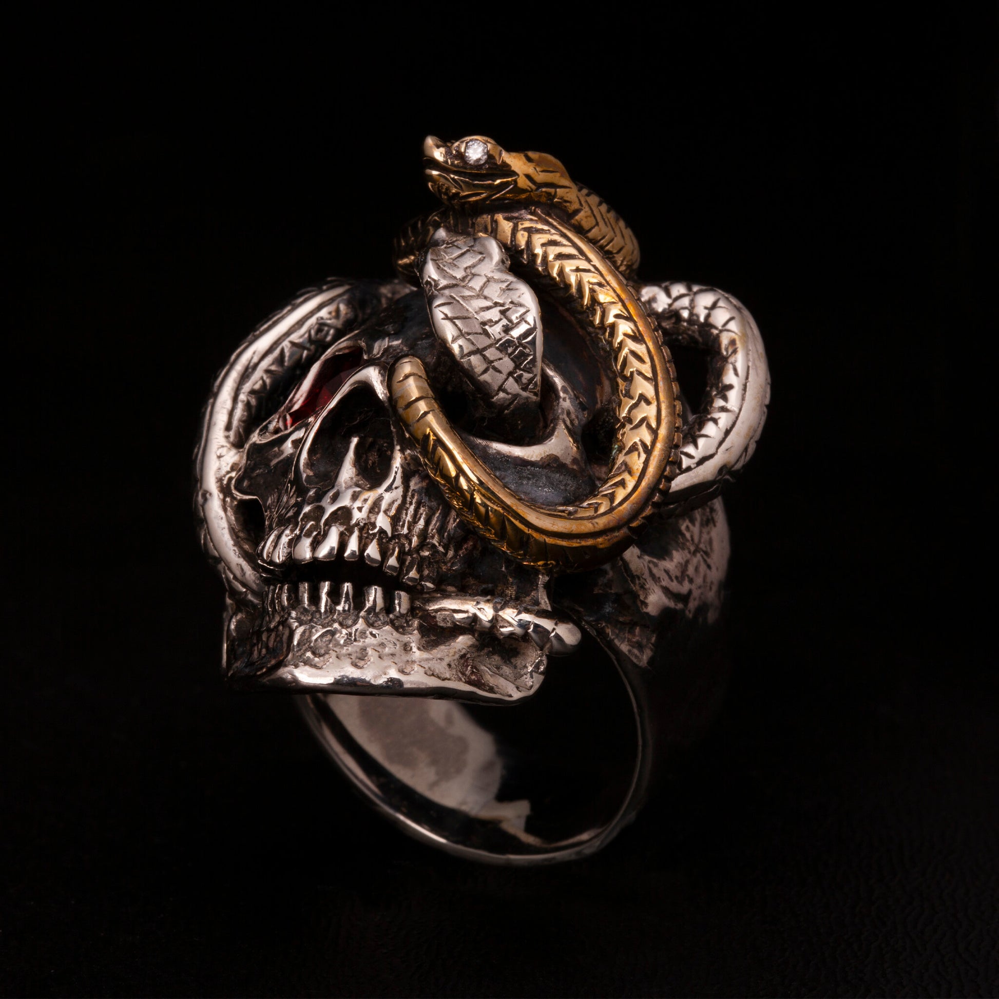 Anello in argento925 con dettaglio di un serpente in ottone. Impreziosito con diamanti naturali e granato.