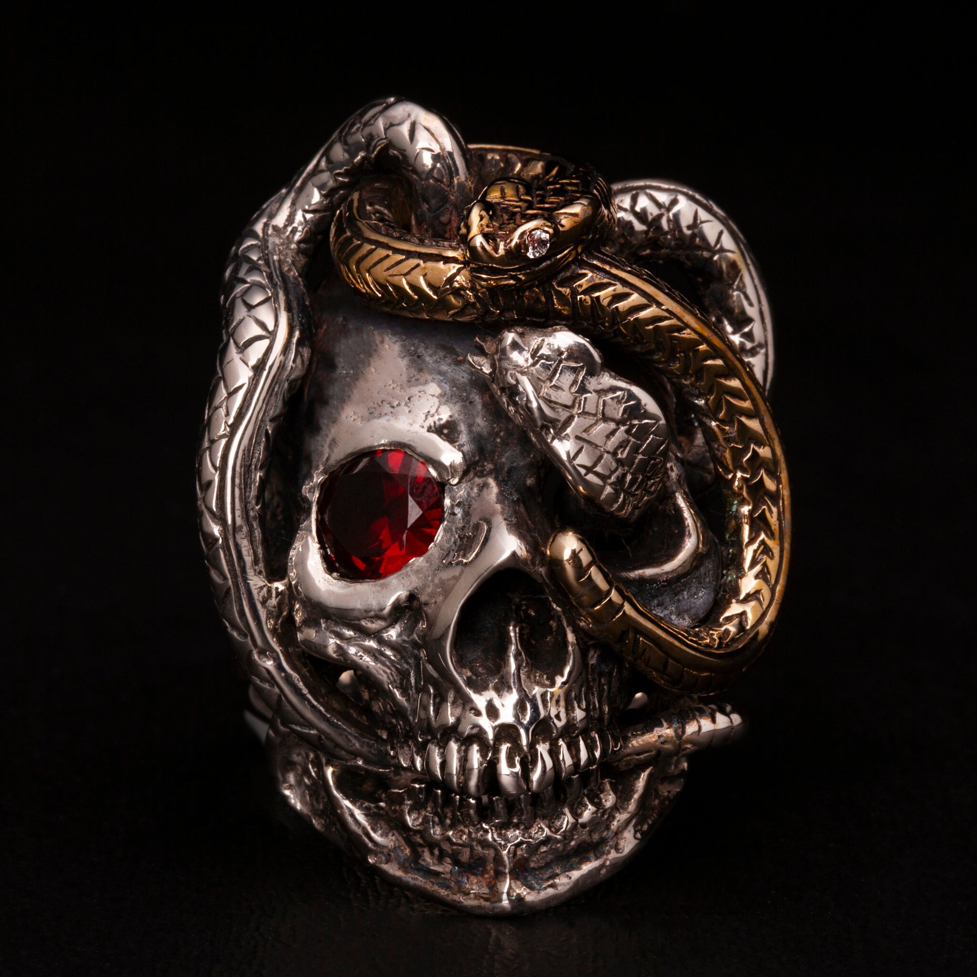 Anello in argento925 con dettaglio di un serpente in ottone. Impreziosito con diamanti naturali e granato.