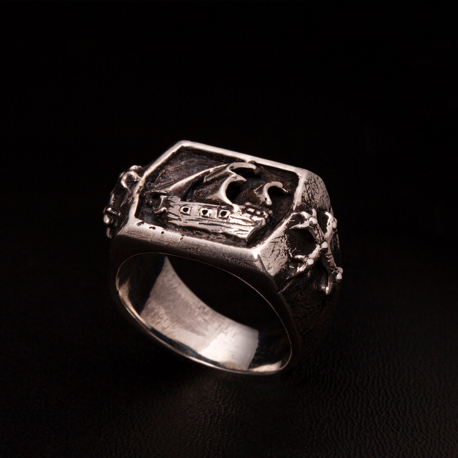 Anello chevalier in argento925 con veliero tridimensionale e croci gotiche nei gambi laterali.
