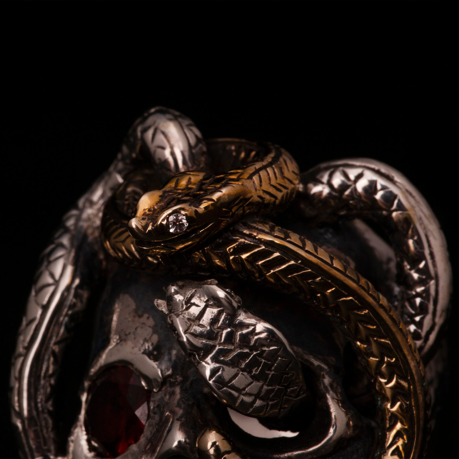 Anello in argento925 con dettaglio di un serpente in ottone. Impreziosito con diamanti naturali e granato.