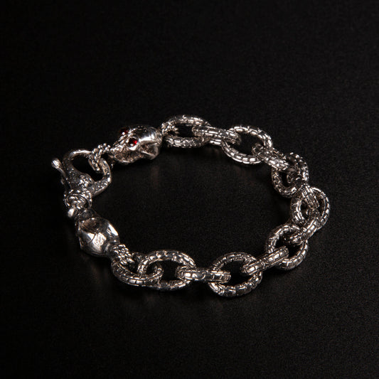 Bracciale in argento925 con maglia rolo' effetto "mattone" e due teschi con granati incastonati nelle orbite come terminali.