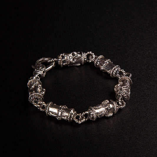 Bracciale in argento 925 con maglie tubolari finemente arricchite con teschi, cuori votivi e croci gotiche.