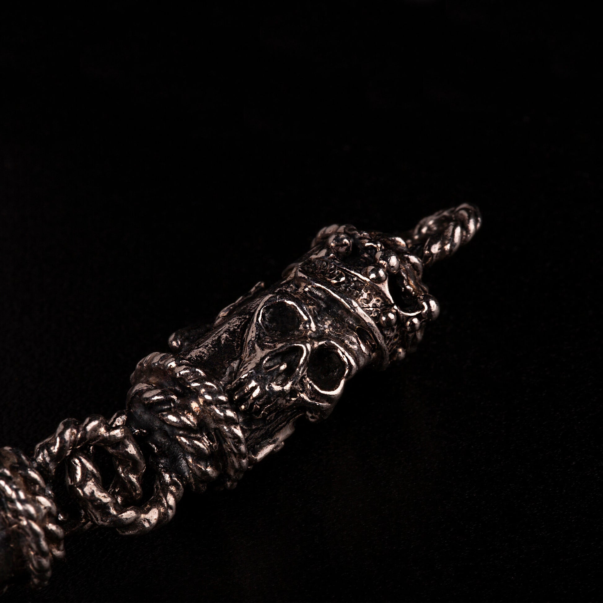 Bracciale in argento 925 con maglie tubolari finemente arricchite con teschi, cuori votivi e croci gotiche.