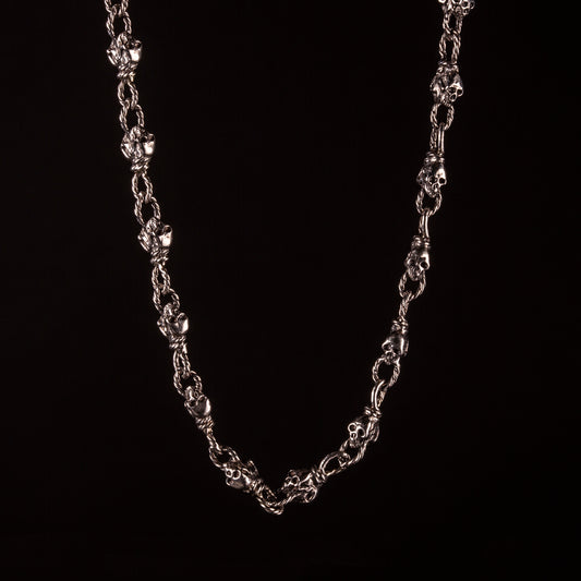 Collana con maglia effetto corda, impreziosita a piccoli teschi alternati a nodi. Creata e saldata interamente a mano.