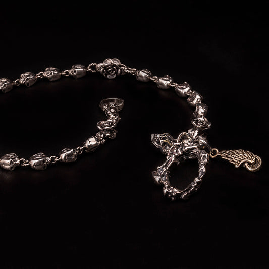 Catena portafoglio in argento925 con teschi e rose. Moschettone a molla formato da ossa incrociate e piccoli teschi.Legati come pendenti al moschettone un teschio e ruota con ala.