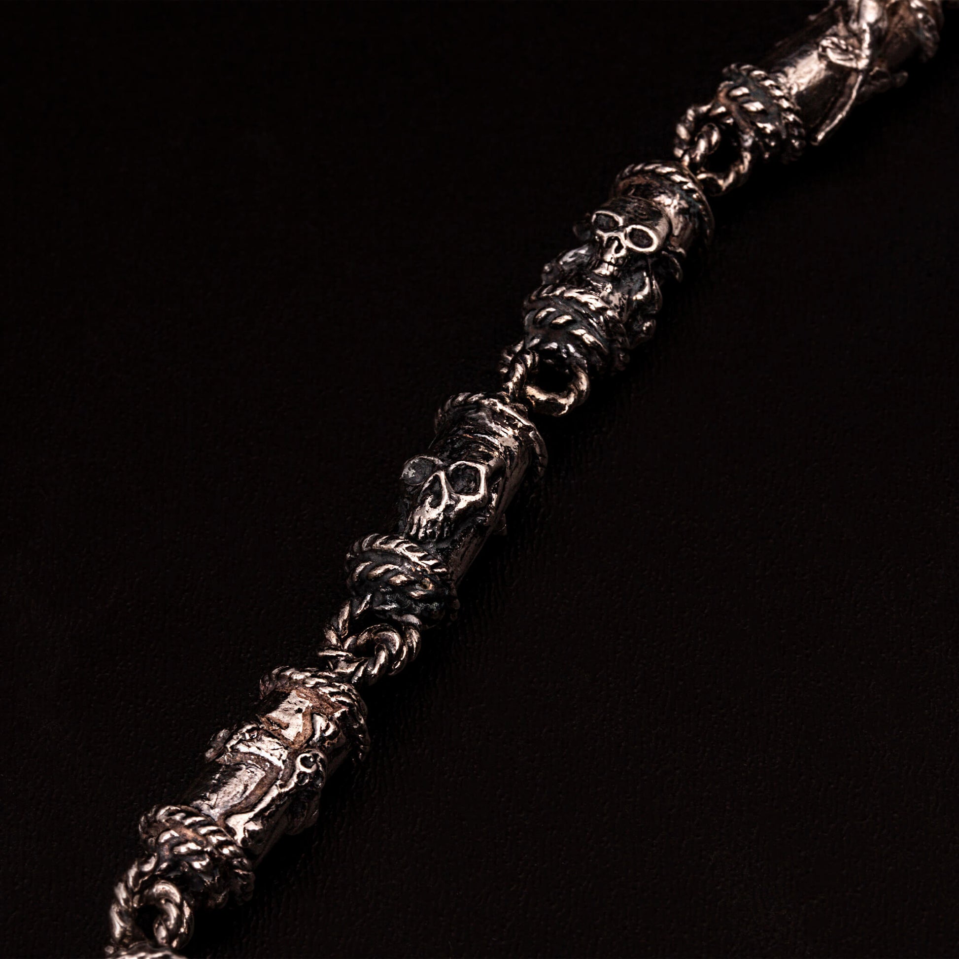 Catena portafoglio n argento925 con elementi tubolari decorati con teschi, cuori votivi, croci gotiche. Moschettone composto da ossa incrociate e teschi, con targhetta ruota e ala e teschio.