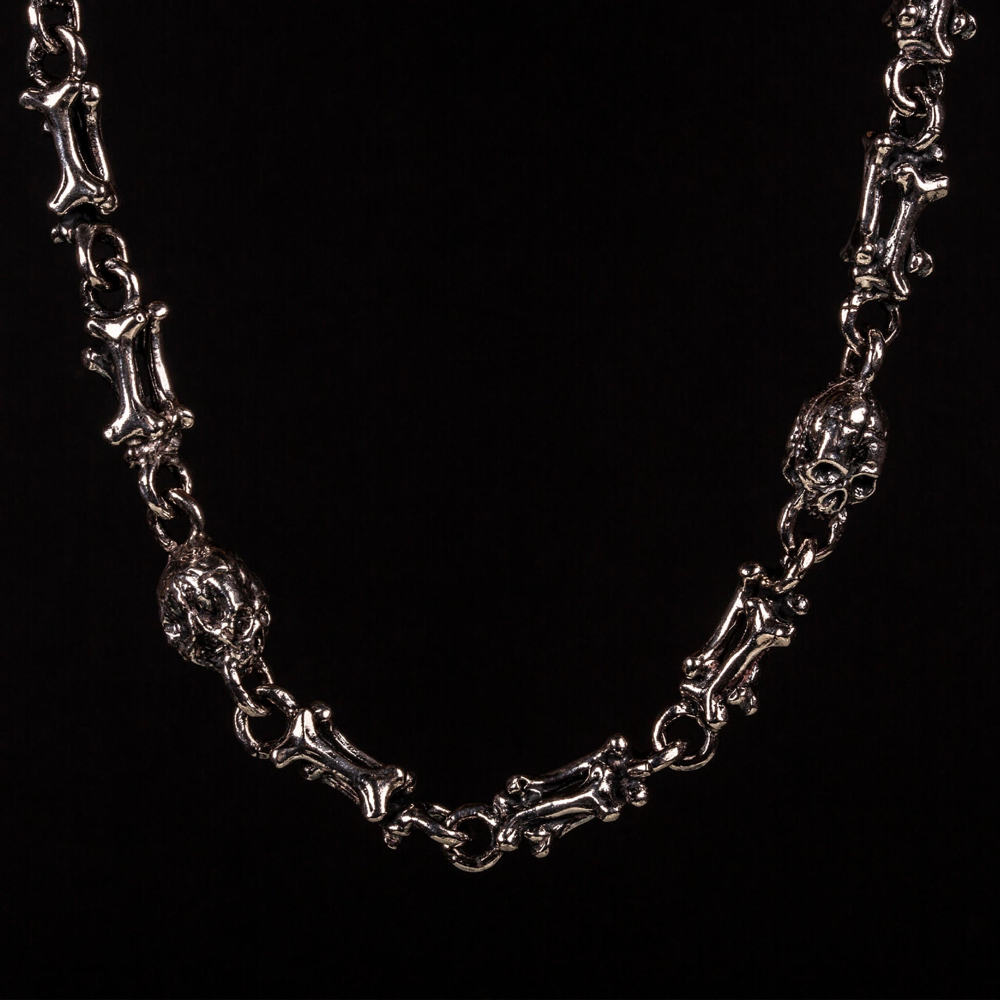 Collana in argeto925 con maglie formate da ossa saldate tra loro e alternate a teschi.