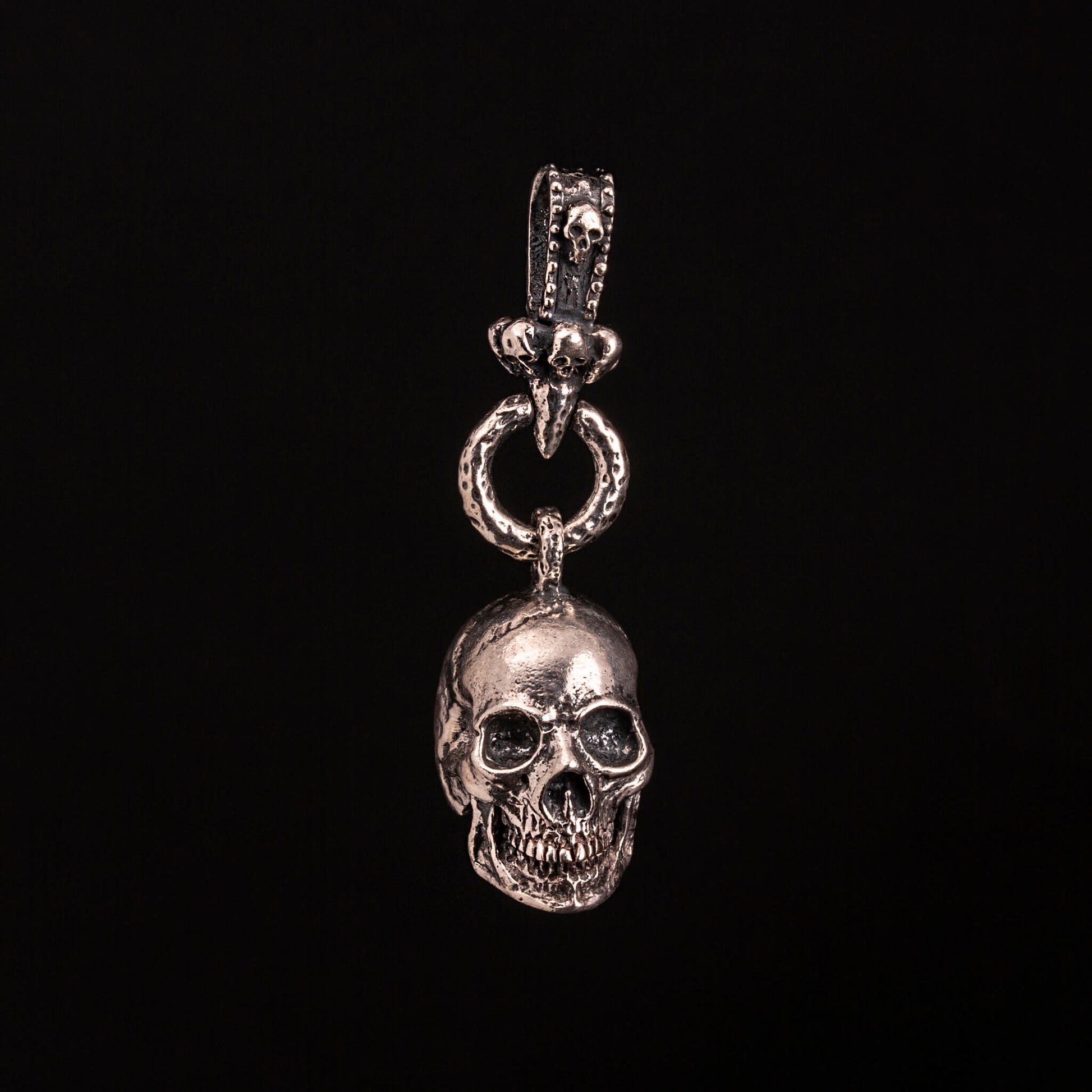 Pendente in argento925 con teschio anatomico. Contromaglia lavorata con piccoli teschietti.