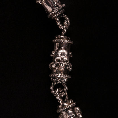 Bracciale in argento 925 con maglie tubolari finemente arricchite con teschi, cuori votivi e croci gotiche.