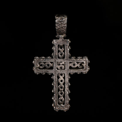 Crux Reliqvia e' un pendente a forma di croce con superficie scalfita irregolare, micro teschi saldati lungo lo spessore e incastonati granati naturali in tutta lunghezza e largezza.